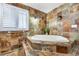 Bathroom with a soaking tub surrounded by patterned tiling at 19070 White Fawn Dr, Monument, CO 80132