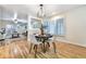 Bright dining room open to the living room features a large window with plantation shutters and hardwood floors at 19070 White Fawn Dr, Monument, CO 80132