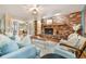 Cozy living room featuring a brick fireplace and an abundance of natural light, great for gathering and relaxation at 19070 White Fawn Dr, Monument, CO 80132