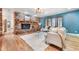 Inviting living room featuring a brick fireplace, hardwood floors, and stylish decor, ideal for relaxing and entertaining at 19070 White Fawn Dr, Monument, CO 80132