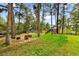 Backyard playground nestled among mature trees creating a fun and shaded play area at 19070 White Fawn Dr, Monument, CO 80132
