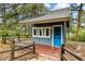 Exterior shot of a well maintained shed with a bright blue door and a small fence around it at 19070 White Fawn Dr, Monument, CO 80132