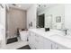Modern bathroom with dual sinks, marble countertops, soaking tub, and glass-enclosed shower at 4243 E 8Th Ave, Denver, CO 80220