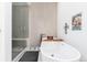 Bright bathroom with sleek white tub, shower, and beige tile at 4243 E 8Th Ave, Denver, CO 80220