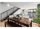 This open dining room features a long wooden table, hardwood floors and black iron stairwell at 4243 E 8Th Ave, Denver, CO 80220