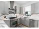 Modern kitchen with stainless steel appliances, gas range, and grey cabinetry at 4243 E 8Th Ave, Denver, CO 80220