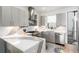 Modern kitchen features grey cabinetry, stainless appliances, and stone backsplash at 4243 E 8Th Ave, Denver, CO 80220