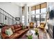 Bright living room featuring hardwood floors, a modern staircase, and large windows at 4243 E 8Th Ave, Denver, CO 80220