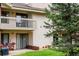 Back exterior view featuring a balcony, patio, and lush green lawn with mature trees at 595 Manhattan Dr # 203, Boulder, CO 80303