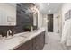 Modern bathroom with double vanity, decorative tile accent wall, and shower over tub with glass doors at 10703 W Turtle Mtn, Littleton, CO 80127