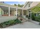 A stone patio with seating, steps to covered porch, grill, and lush landscaping at 3109 E Warren Ave, Denver, CO 80210