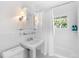 Updated all-white bathroom with tiled walls, sink, medicine cabinet, and shower-tub combo at 3109 E Warren Ave, Denver, CO 80210