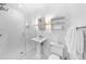 Modern bathroom features a glass enclosed shower, pedestal sink, and updated fixtures at 3109 E Warren Ave, Denver, CO 80210