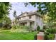 Beautifully landscaped home with a lush green lawn, mature trees, and a covered front porch at 3109 E Warren Ave, Denver, CO 80210