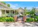 Beautiful home with inviting porch, well-manicured lawn, landscaping, and gate at 3109 E Warren Ave, Denver, CO 80210