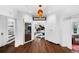 Hallway featuring a wine fridge, white built-in cabinets, and hardwood floors with view to music room at 3109 E Warren Ave, Denver, CO 80210