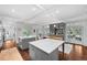 Open floor plan with a kitchen island, dining table, and access to the outdoors, with hardwood floors and white trim at 3109 E Warren Ave, Denver, CO 80210