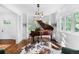 Sunlit sitting room with a grand piano, hardwood floors, and large windows overlooking the outdoor landscape at 3109 E Warren Ave, Denver, CO 80210
