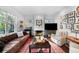 Comfortable living room with a brick fireplace, large windows, and a mix of leather and upholstered seating at 3109 E Warren Ave, Denver, CO 80210