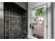 Mud room with dark tile shower and a white, glass-paneled door to the exterior brick patio at 3109 E Warren Ave, Denver, CO 80210