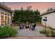 Charming outdoor patio with a fire pit surrounded by seating and lush greenery at 3109 E Warren Ave, Denver, CO 80210