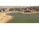 Aerial view of a pond with a clubhouse, walking path, and surrounding neighborhood at 11041 Richfield Cir, Commerce City, CO 80022
