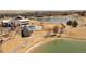 Aerial view of a park with a playground and walking trails near a pond and homes at 11041 Richfield Cir, Commerce City, CO 80022