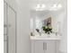 Bathroom featuring dual sinks, framed mirror, vanity lights, and glass shower door at 11041 Richfield Cir, Commerce City, CO 80022