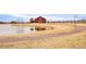 Picturesque community pond surrounded by a walking trail and a red barn, offering a peaceful outdoor space at 11041 Richfield Cir, Commerce City, CO 80022