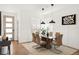 Bright dining area with modern light fixture, glass table, decor, and white wall paneling at 11041 Richfield Cir, Commerce City, CO 80022
