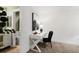 Clean, minimalist office setup with a white desk, modern chair, and artistic accents, adjacent to bathroom at 11041 Richfield Cir, Commerce City, CO 80022