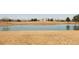Scenic view of a pond in a community park with a building and mountains in the background at 11041 Richfield Cir, Commerce City, CO 80022