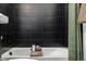 Close-up of a modern bathtub with black tile surround and elegant fixtures at 4465 Mesa Top Dr, Monument, CO 80132