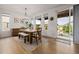 Bright dining room featuring natural wood furniture, a stylish chandelier, and a sliding glass door at 4465 Mesa Top Dr, Monument, CO 80132