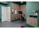 Home gym has a Peloton, green walls with light wood accents, and black rubber flooring at 4465 Mesa Top Dr, Monument, CO 80132
