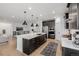 Open kitchen boasts a large island with seating, stainless appliances, and modern lighting at 4465 Mesa Top Dr, Monument, CO 80132