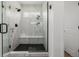 This modern shower features white marble tile and a black shower base at 4465 Mesa Top Dr, Monument, CO 80132