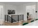 Modern staircase with sleek metal railings and hardwood floors leading to open living space at 4465 Mesa Top Dr, Monument, CO 80132