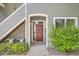Charming condo entrance with a red door, sidewalk, and verdant landscaping at 8500 E Jefferson # 3C, Denver, CO 80237