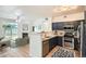 Stylish kitchen featuring stainless steel appliances, navy blue cabinets, and a breakfast bar overlooking the living area at 8500 E Jefferson # 3C, Denver, CO 80237