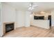 Open-concept living room with fireplace flows seamlessly into kitchen with stainless steel appliances at 8500 E Jefferson # 3C, Denver, CO 80237