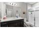 Bathroom featuring a shower, large mirror, vanity with dark cabinets, and framed art at 13673 Osage St, Broomfield, CO 80023
