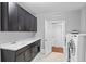 Well-lit laundry room featuring sleek cabinetry, modern washer and dryer, and utility sink at 13673 Osage St, Broomfield, CO 80023