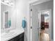 Modern bathroom featuring a dark vanity, a sink with a towel and a view of the bedroom at 13673 Osage St, Broomfield, CO 80023