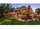 Backyard featuring a two-level deck, outdoor seating, and mature trees providing shade at 11796 W 53Rd Pl, Arvada, CO 80002