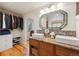 Bathroom featuring double sinks with designer faucets, wood floors, and a separate closet/dressing area at 11796 W 53Rd Pl, Arvada, CO 80002