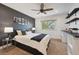 Stylish bedroom with a dark accent wall, large window, and a ceiling fan, offering a modern design at 11796 W 53Rd Pl, Arvada, CO 80002