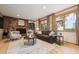 Cozy living room with stone fireplace, built-in shelving, and an abundance of natural light from large windows at 11796 W 53Rd Pl, Arvada, CO 80002