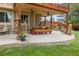 Inviting covered outdoor patio with a wood picnic table, grill, ceiling fans, and decorative lighting at 11796 W 53Rd Pl, Arvada, CO 80002