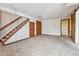 Spacious carpeted room with stairs and wooden doors, providing ample storage and access at 7696 S Monaco E Cir, Centennial, CO 80112